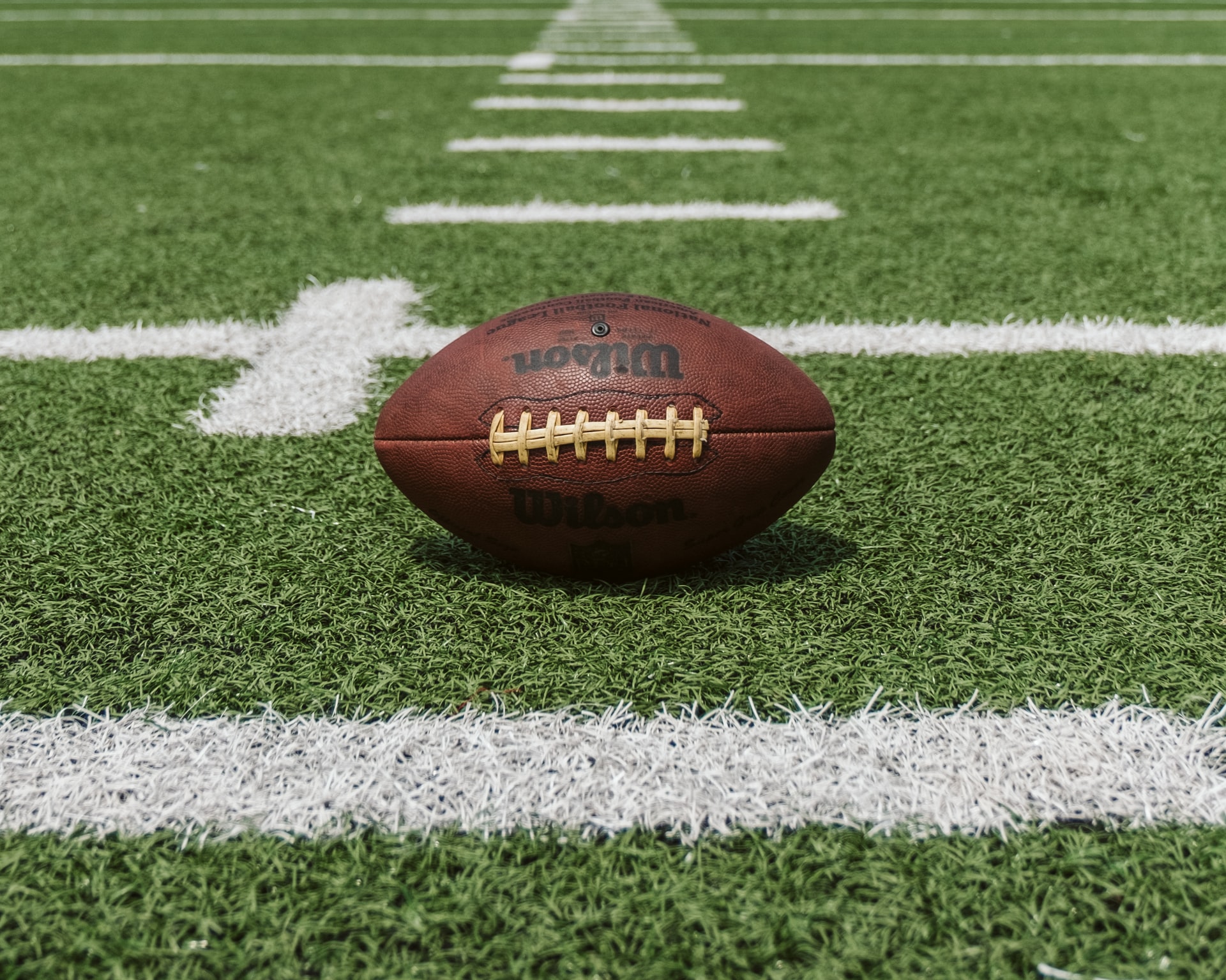 A picture of a football on a football field used by many athletes as they grow and develop useful life skills