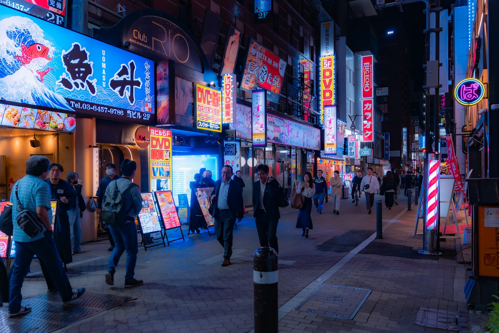 a crowded city street at night with neon signs